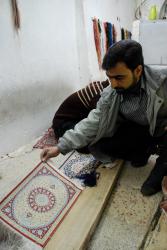 Repairing miniature carpets in Qom