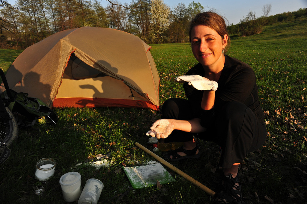 Tara wild camping and rolling out dough for dinner.